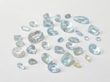 a lot of blue topaz gems on a white surface