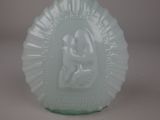 a green glass vase with a picture of a woman on it