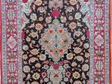 un tapis noir et rouge orné d'un motif floral