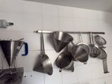 de nombreuses casseroles et poêles accrochées au mur de la cuisine