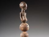 une image représentant une sculpture d'une femme assise sur une boule