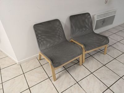 two chairs in the corner of a room with tile flooring