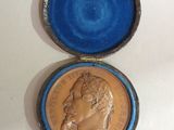 an old coin in a blue box with a gold crown on it