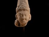 un gros plan d'une statue représentant une tête sur fond noir