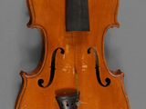 an old violin with a black bow on a gray background