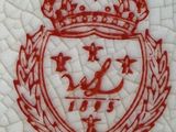 a close up of a red and white tile with a crown on it