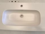a white sink sitting on top of a white counter