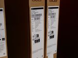 two boxes of acer products sit on a shelf in front of a red wall