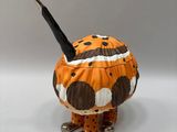 a figurine of a person wearing a pumpkin costume