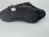 a black shoe with a tag on it on a white surface