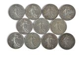six quarters of silver coins are arranged in a row on a white surface