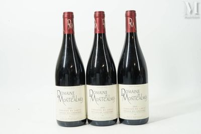 trois bouteilles de vin rouge posées sur une table blanche