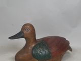 a wooden duck that is sitting on a table