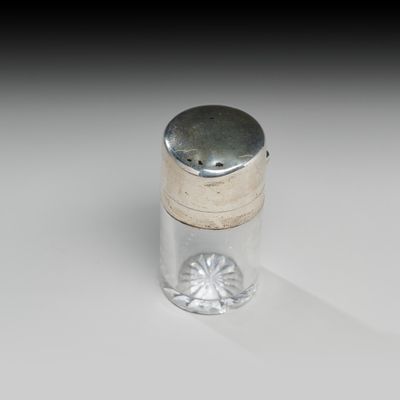 une petite bouteille en verre avec un bouchon argenté