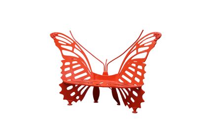 un papillon rouge posé sur une surface blanche