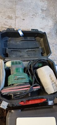une boîte à outils contenant des outils, posée sur le sol