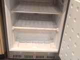 a small refrigerator with its door open in a kitchen