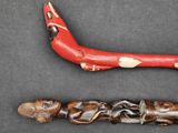 deux sculptures en bois représentant un homme et une femme sur un fond noir
