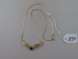 collier plaqué or orné d'une pierre verte sur fond blanc