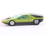 a green toy car that is sitting on a white surface