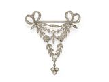 an antique diamond broochle with a bow
