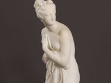 an image of a statue of a woman with a flower in her hand