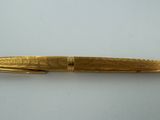 a close up of a pen on a table with a white background