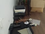 un bureau sur lequel se trouvent un ordinateur portable, une imprimante et d'autres objets