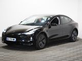 une Tesla noire garée dans une pièce au sol en damier