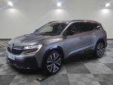 un SUV gris garé sur un sol à damier dans un garage