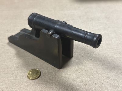 a close up of a small gun on a table next to a coin