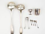 several silver spoons, cups, and spoon spoons laid out on a white surface