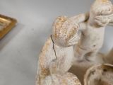 a figurine of a man and a woman holding a bowl