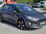 La Ford Fiesta grise est garée sur un parking, à côté d'autres voitures.