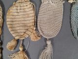 three small bags with tassels are lined up on a table