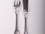 two forks and a knife on a white table