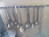 a lot of spoons hanging from the wall in the kitchen