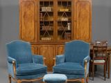 deux chaises bleues et une table dans une pièce où se trouve une bibliothèque
