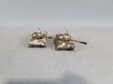 two toy tanks sitting on top of a table next to each other