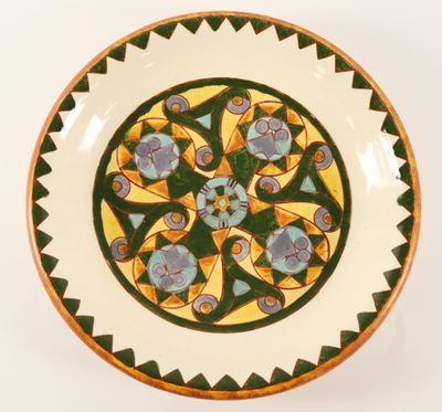 a green and yellow plate with a flower design on it