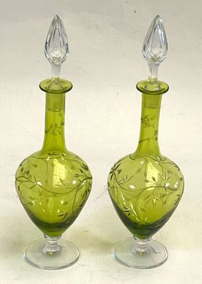 two green glass vases sitting on a white surface