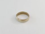 gros plan d'une bague en or sur une surface blanche