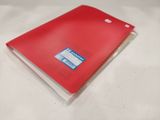 a red notebook with a clear cover sitting on top of a white table