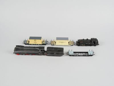 quatre types différents de petits trains posés sur une surface blanche
