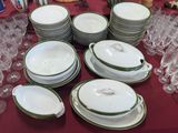 many plates and bowls on a table with wine glasses