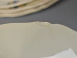 a close up of a plate on a table with other plates in the background