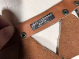 a close up of a person ' s hand holding a piece of leather on a mannequin