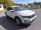 a white volkswagen suv parked in a parking lot next to a building