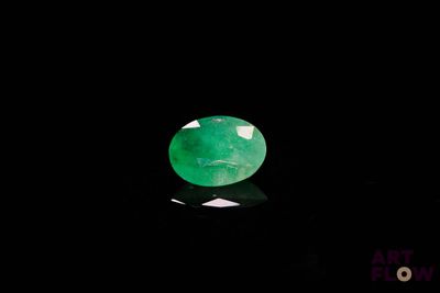 un gros plan d'une pierre de jade verte sur une surface noire