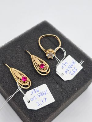 trois paires de boucles d'oreilles en or et rubis présentées dans un écrin noir